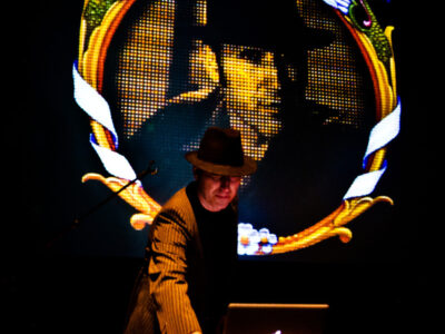 Live-Event: Musiker mit Hut vor LED-Wand. Konzert-Atmosphäre.