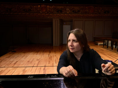 Frau am Klavier auf Bühne. Konzert, Musikerin, Veranstaltung.