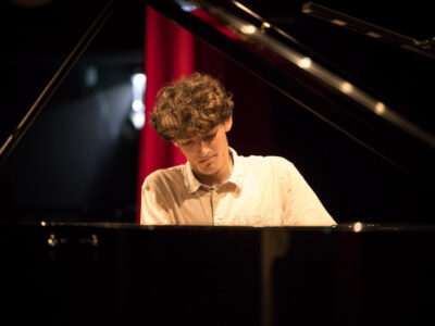 Junger Mann spielt Klavier. Konzert, Musik, Pianist.